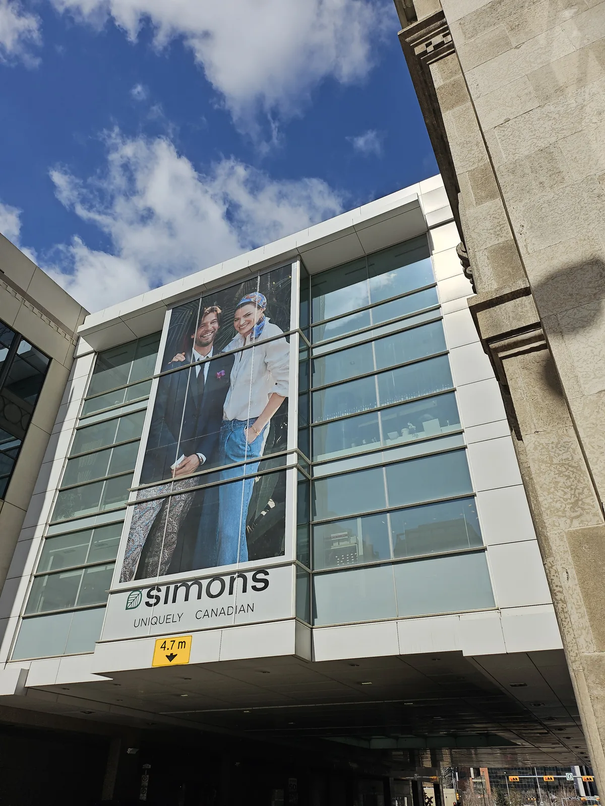 Large format building facade wrap installation Calgary — scale reference